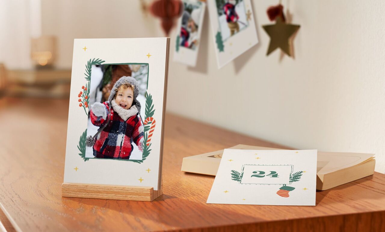 Et dekorativt bord med en billedramme og kort, festligt designet med julemotiver.